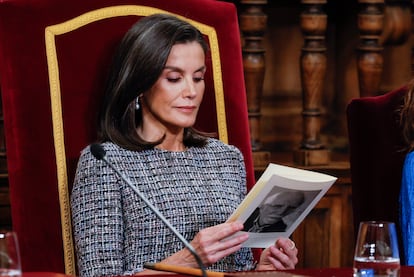 La reina Letizia ojea un folleto con la imagen del escritor español galardonado Luis Mateo Díez.