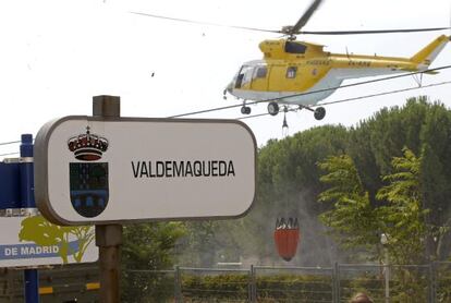 A helicopter collects water from a swimming pool to battle the blaze in Valdemaqueda, Madrid.