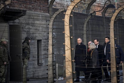 El presidente polaco, Andrzej Duda (a la izquierda), camina entre vallas de alambre de espino en el antiguo campo de concentración y exterminio nazi alemán de Auschwitz-Birkenau, en Oswiecim, Polonia.