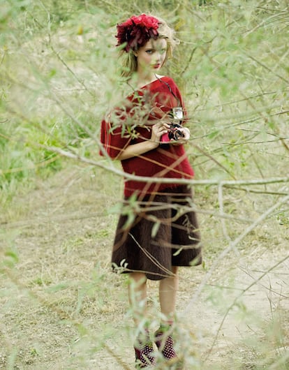 Blusa de algodón con lunares rojos y falda de seda con lunares negros. Bolso de loneta y cuero. Zapatos con plataforma de madera. Todo de Marni. Calcetines negros de Cóndor. Gafas rosas de Super y cámara Diana + de Lomography.