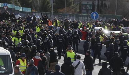 Carga de los antidisturbios tras el corte de la M-40, durante las protestas de los taxistas, ayer en los alrededores de Ifema. 