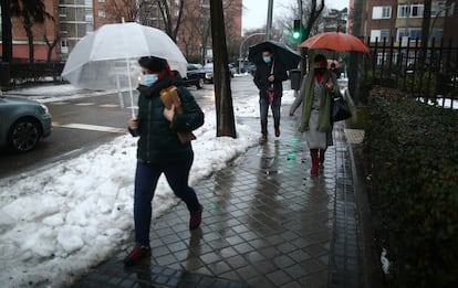Varias personas caminan por una calle de la capital con las primeras lluvias del temporal ‘Gaetán’.