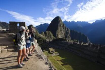 Turistas en Machu Picchu, Perú, con el pico Huayna Picchu al fondo.