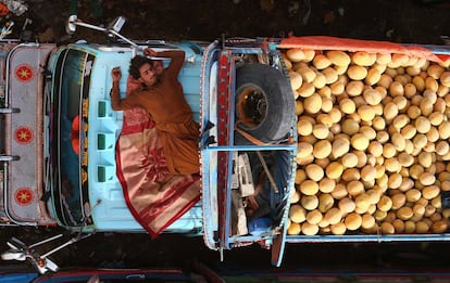 Un vendedor se echa una siesta en su furgoneta donde vende melones en un mercado en Karachi (Pakistán).