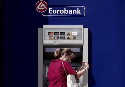Una mujer saca dinero en un cajero de Eurobank, en Atenas.