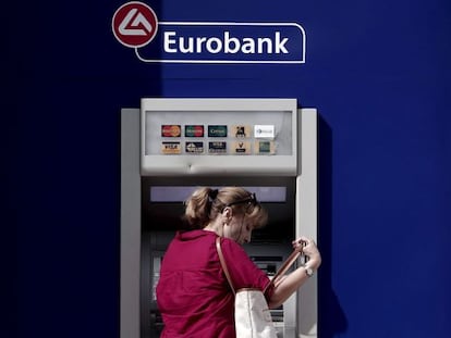 Una mujer saca dinero en un cajero de Eurobank, en Atenas.