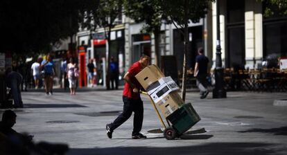 Un repartidor transporta diverses caixes al centre de Madrid