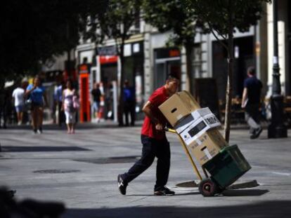 Un repartidor transporta diverses caixes al centre de Madrid