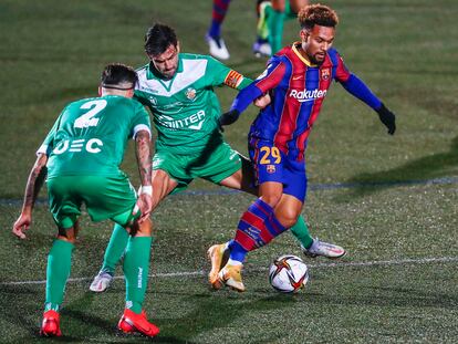 Konrad, del Barcelona, entre dos jugadores del Cornellà.