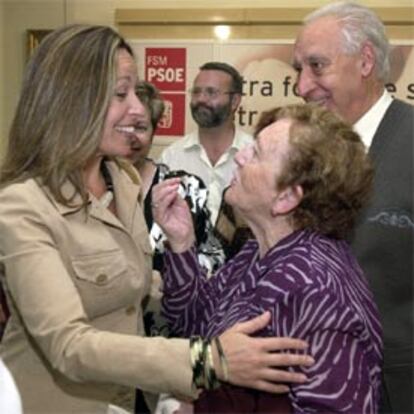 Trinidad Jiménez saluda a dos veteranos militantes socialistas hoy durante su visita a la sede de la Federación Socialista Madrileña del distrito centro.