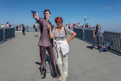 Una turista posa al lado de una fotografía del actor George Lazenby en el restaurante giratorio Piz Gloria, en la cumbre del Schilthorn, donde se rodó la película '007 al servicio de Su Majestad'.