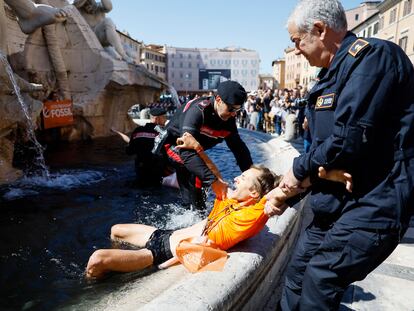 Los activistas de Ultima Generazione son sacados a la fuerza por la policía de la fuente de los Cuatro Ríos, en la plaza Navona, en Roma.