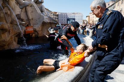 Los activistas de Ultima Generazione son sacados a la fuerza por la policía de la fuente de los Cuatro Ríos, en la plaza Navona, en Roma.