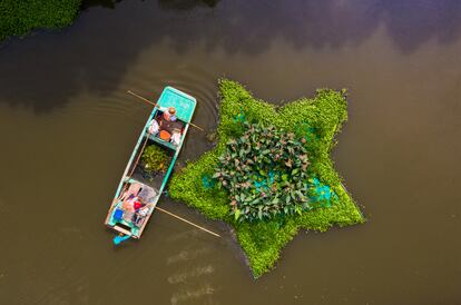 Dos hombres recogen basura en el río en la provincia china de Nantong.