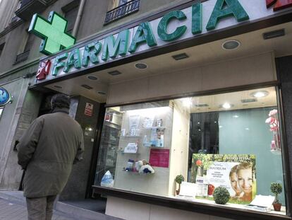 Un hombre camina ante una farmacia situada en la madrile&ntilde;a calle de R&iacute;os Rosas. 