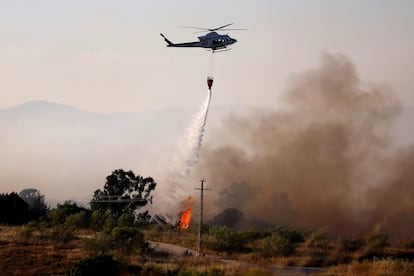 Un helicóptero descarga agua sobre las llamas en Valmojado (Toledo), este jueves.