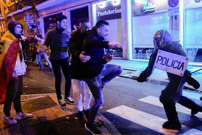 Un agente de los antidisturbios carga contra un grupo de manifestantes en los aledaños de la calle Ferraz. 