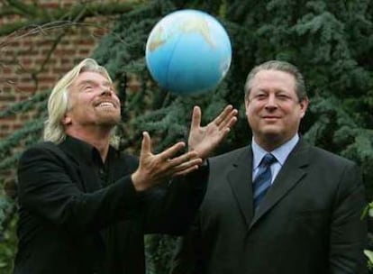 Richard Branson, a la izquierda, lanza al aire un globo terráqueo en presencia de Al Gore.