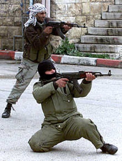 Los palestinos combaten calle por calle con las tropas israelíes que toman al asalto Ramala. Uno de los milicianos que aparece en esta foto (el del pañuelo en la cabeza) caería abatido a tiros por los soldados poco después (REUTERS).