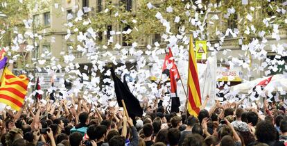 Los manifestantes lanzan papeletas en una protesta frente a la sede del PP en Cataluña.