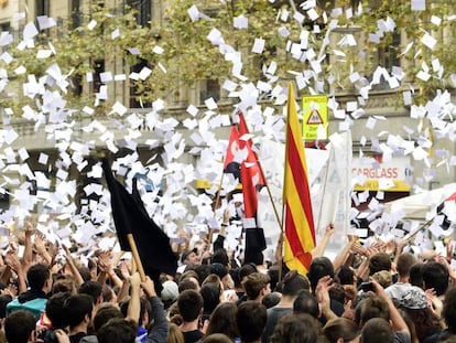 Los manifestantes lanzan papeletas en una protesta frente a la sede del PP en Cataluña.