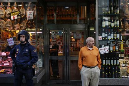 Un agente de policía custodia la entrada de un comercio durante la huelga general del 14-N en Madrid