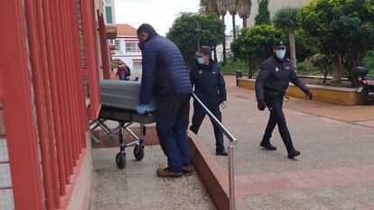 Trabajadores del tanatorio retiran el cuerpo sin vida de la mujer asesinada en Ceuta, este lunes.