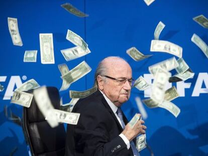 El president de la FIFA, Joseph Blatter, sota una pluja de bitllets de dòlar.