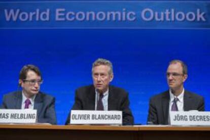 Fotografía facilitada por el Fondo Monetario Internacional que muestra al economista jefe del FMI, Olivier Blanchard (c) junto con el vicepresidente del Departamento de Investigación Jorg Decressin (d) y el consejero de dicho departament Thomas Helbling (i) durante la rueda de prensa ofrecida en Washington, Estados Unidos.