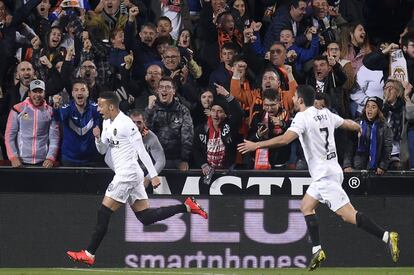 El delantero del Valencia, Rodrigo Moreno, celebra su gol anotado al Betis junto a su compañero Guedes y a la afición.