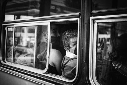 Un hombre observa por la ventanilla del autobús el tráfico detenido.