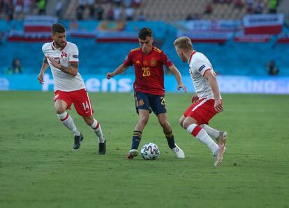 Pedri ante dos jugadores de la selección de Polonia.