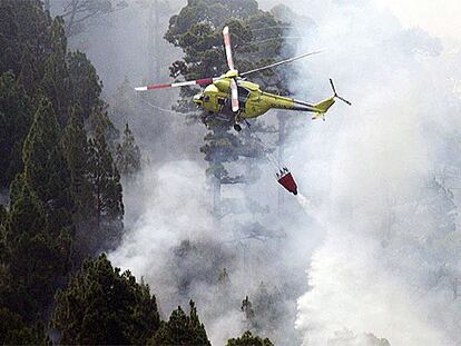 Un helicóptero suelta agua sobre el fuego originado el martes por causas desconocidas en el municipio de Garafía.