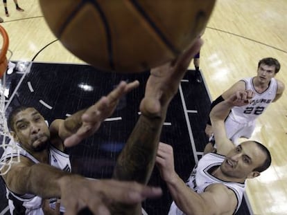 Duncan y Ginobili tratan de parar el lanzamiento de un rival.