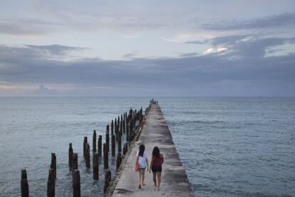 Women walk on the old part of the British Bridge at Iracema beach during sunset in Fortaleza, Brazil, Saturday, April 26, 2014. Fortaleza is one of the host cities of the 2014 soccer World Cup. (AP Photo/Felipe Dana)