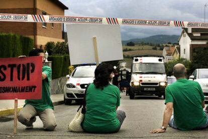 Miembros de la plataforma protestan por el desahucio detrás del cordón policial.