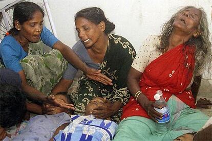 Tres mujeres lamentan la muerte de sus hijos en la ciudad india de Chennai a consecuencias de las olas gigantescas provocadas por el terremoto que sacudió anoche el Golfo de Bengala.