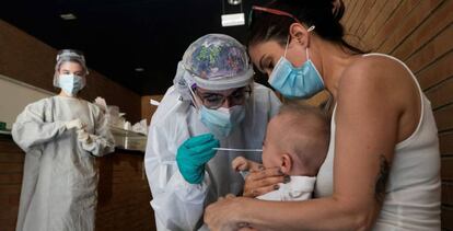 Una sanitaria realiza un test PCR a un niño en un espacio habilitado fuera de un Centro de Salud de la ciudad de Zaragoza.