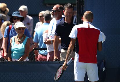 Tim Henman aconseja a Evans en un partido.