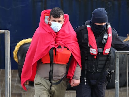 Un inmigrante custodiado por la policía británica de fronteras, el 24 de marzo de 2021 en la localidad costera de Dover