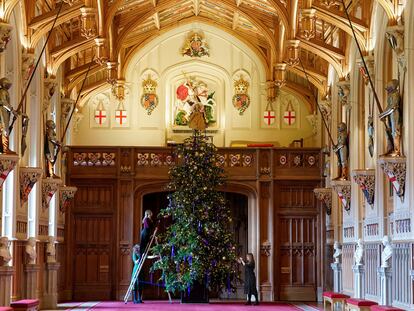 Miembros del Royal Collection Trust decoran el árbol de 6 metros de altura en el salón de San Jorge, en Windsor, tomado de uno de los parques de los alrededores, y vestido con cientos de luces y adornos.