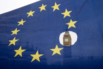 El Big Ben se observa a través de una bandera europea agujereada.