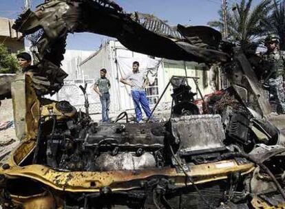 Restos de un vehículo en el lugar del atentado perpetrado ayer en Bagdad.