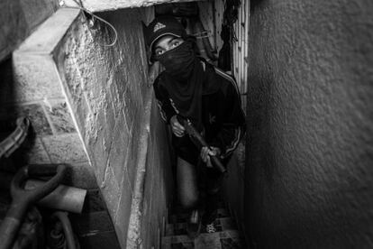 Freddy, de 16 años, miembro de una banda de secuestradores, fotografiado en una casa segura de una barriada de Caracas. Se unió a la banda porque “las cosas eran difíciles en casa. Vi a mi mamá que luchaba para comprar harina, arroz... Empecé como un ladrónpero ahora me han dado un arma para participar también en secuestros”.