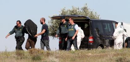 Agentes de la Guardia Civil trasladan ayer al hombre tras el registro de la finca de Toledo.