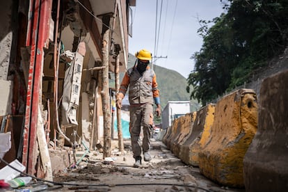 Un trabajador camina entre las casas afectadas por el derrumbe.
