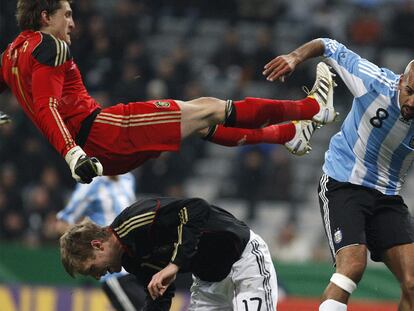 Adler, el portero alemán, salta sobre Mertesacker y Verón trata de cubrirse