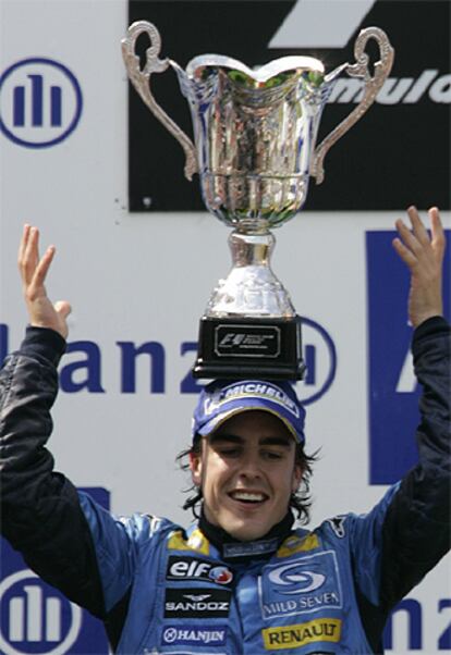 Fernando Alonso, con el trofeo sostenido en equilibrio en la cabeza y sin manos, celebra su victoria en Nürburgring.