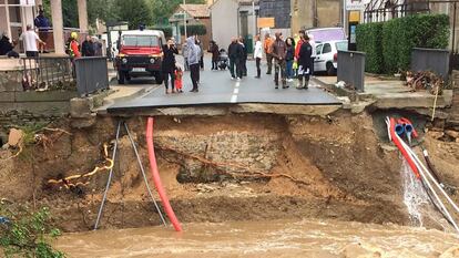 Moradores ao lado de uma ponte sobre o rio Trapel arrancada pela força da água em Villegailhenc, perto de Carcassonne.