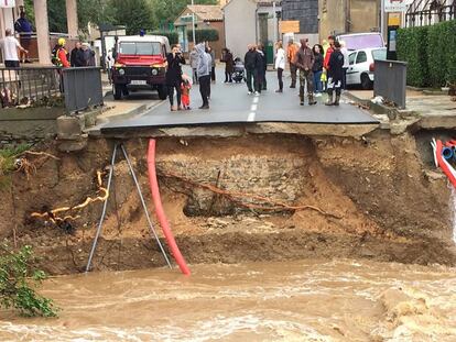 Moradores ao lado de uma ponte sobre o rio Trapel arrancada pela força da água em Villegailhenc, perto de Carcassonne.